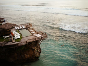 Aerial view of a cliffside villa resort in Bali with the ocean below