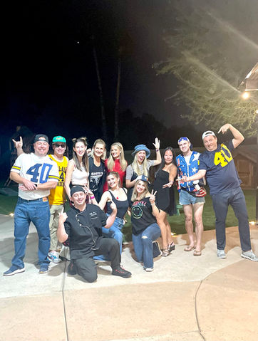 Group photo of Chef Turner with a large gathering of guests, smiling together in a celebratory setting.