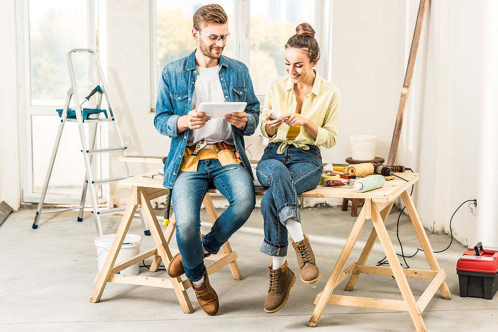A happy couple using digital devices to plan the construction of their modern farmhouse, showcasing the process of building a custom home with Jacob's Construction.