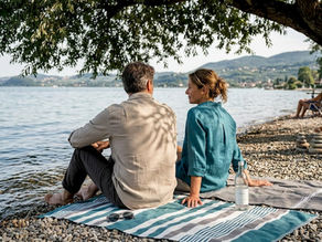 Due innamorati si godono un momento di relax sulla spiaggia del Lago di Garda.