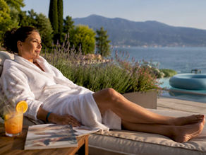 Una donna si concede un momento di puro relax nella spa di un elegante hotel affacciato sul Lago di Garda.
