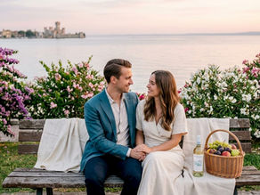 Una coppia si gode un momento romantico ammirando il tramonto sulle rive del Lago di Garda.