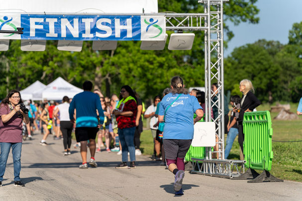 Running Strong member about to cross finish line at race.
