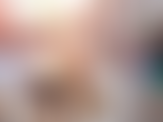 Shoppers walk along a sunlit outdoor mall. People carry brown paper bags, wearing casual clothes, while others browse shop windows.