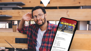 Man in plaid shirt smiling at a cafe table with a coffee cup; smartphone displaying the Driftscape digital tourism app shows an AI generated restaurant listing for Napoli Ristorante Pizzeria.