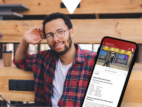 Man in plaid shirt smiling at a cafe table with a coffee cup; smartphone displaying the Driftscape digital tourism app shows an AI generated restaurant listing for Napoli Ristorante Pizzeria.