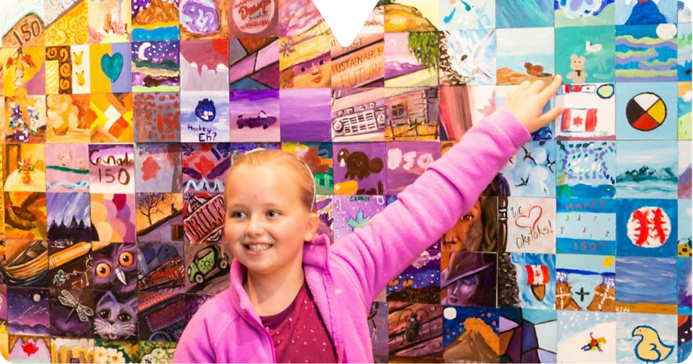 Girl in a pink jacket pointing at a colorful mural of small paintings, smiling. Background features diverse artwork and patterns.