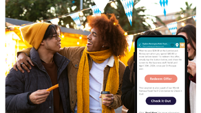 Two people smile at each other outdoors, one holding a corndog, the other a drink. A phone displays the Driftscape coupon management app.