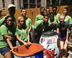 Eco-Ambassadors pose with rain barrels they painted.