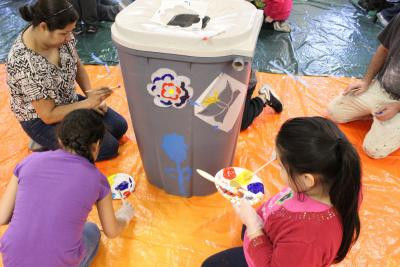 The gray rain barrel gets flowers & butterflies!