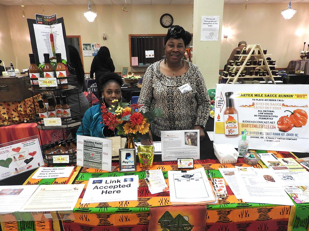 Dorcas Bishop, Owner of Quarter Mile Runnin' Hot Sauce, and her granddaughter at the Winter Farmers Market