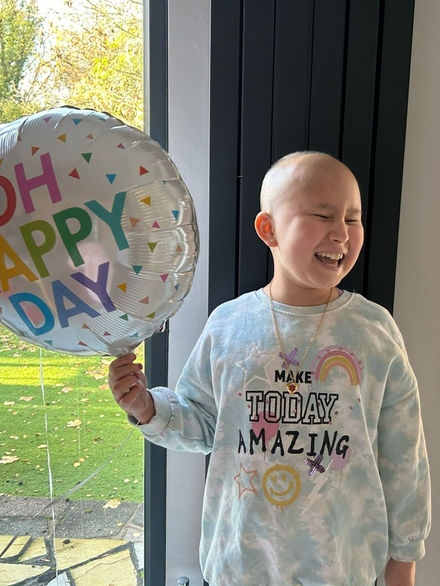 A little girl holding a balloon, celebrating her 10th birthday