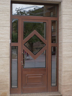 Puerta aluminio con cristal reflex.