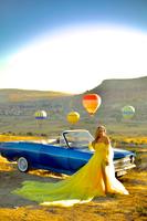 Rasha in a yellow dress with hot air balloons in Cappadocia