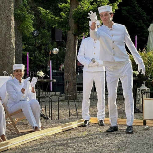 Un lobby-boy joue sur un terrain de pétanque éphémère