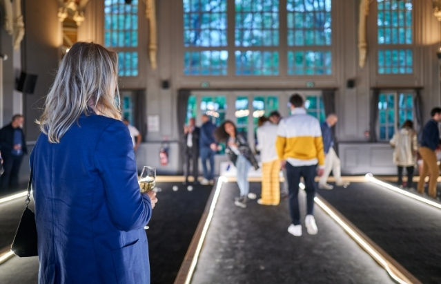 Une femme assiste à une animation pétanque dans un lieu événementiel à Paris