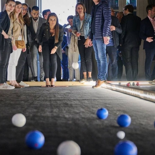 Une femme joue à la pétanque sur un terrain de pétanque d'intérieur lors d'une soirée corporate