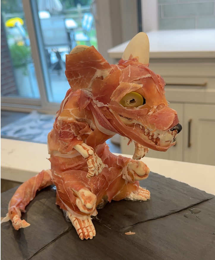 A fake rat skeleton wrapped in prosciutto for a Halloween charcuterie board.