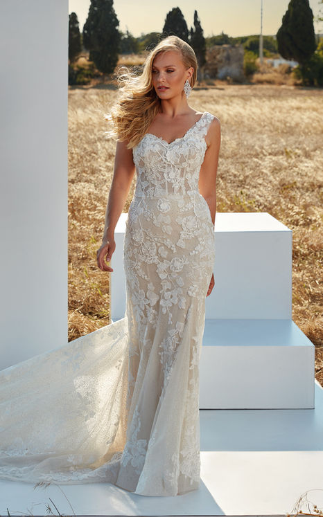 blonde model with hair blowing in the wind wearing one strap fit-n-flare lace wedding dress