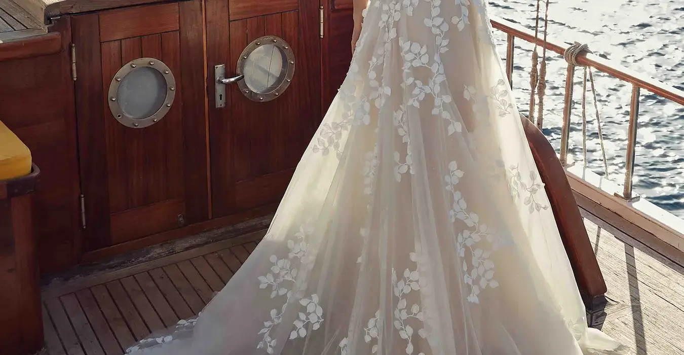 Back of a Sleeveless wedding gown by Italian wedding dress designer Eddy K with a sweetheart neckline and floral appliqués from the neckline to the train
