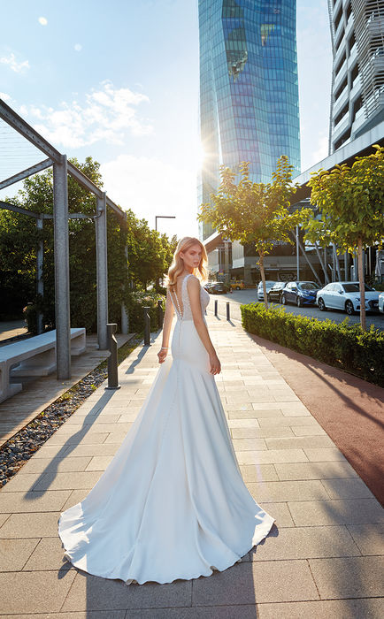 Eddy K fit-n-flare sleeveless wedding dress over tulle and crepe skirt on bride standing in the city