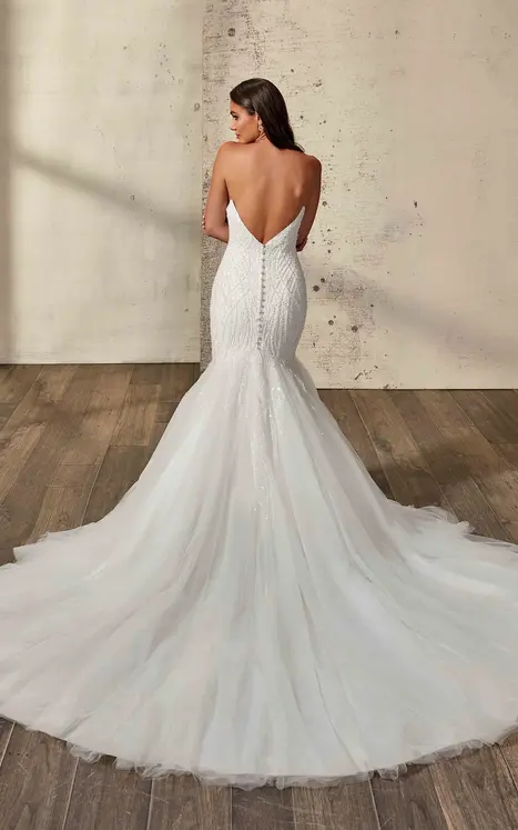 bride wearing mermaid gown by wedding dress designer, Eddy K with pearl beaded ivory embroidery over Mikado, tulle skirt, ivory matte lining, pearl buttons over zipper to skirt break. She is photographed in a studio
