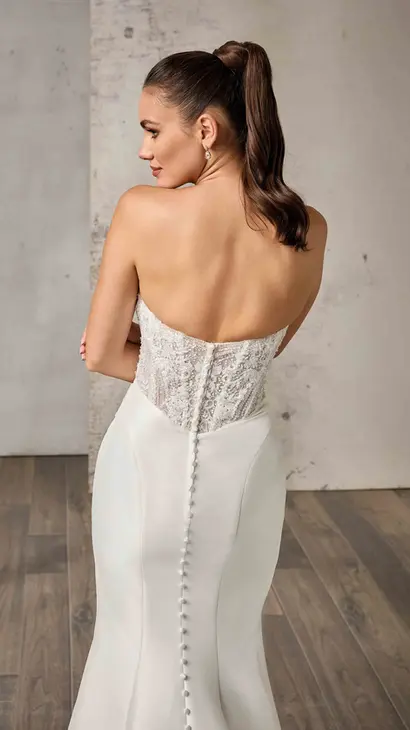Close up back of Eddy K mikado fit-n-flare wedding dress with a sweetheart neckline and a strapless body on a bridal model standing in a bridal studio