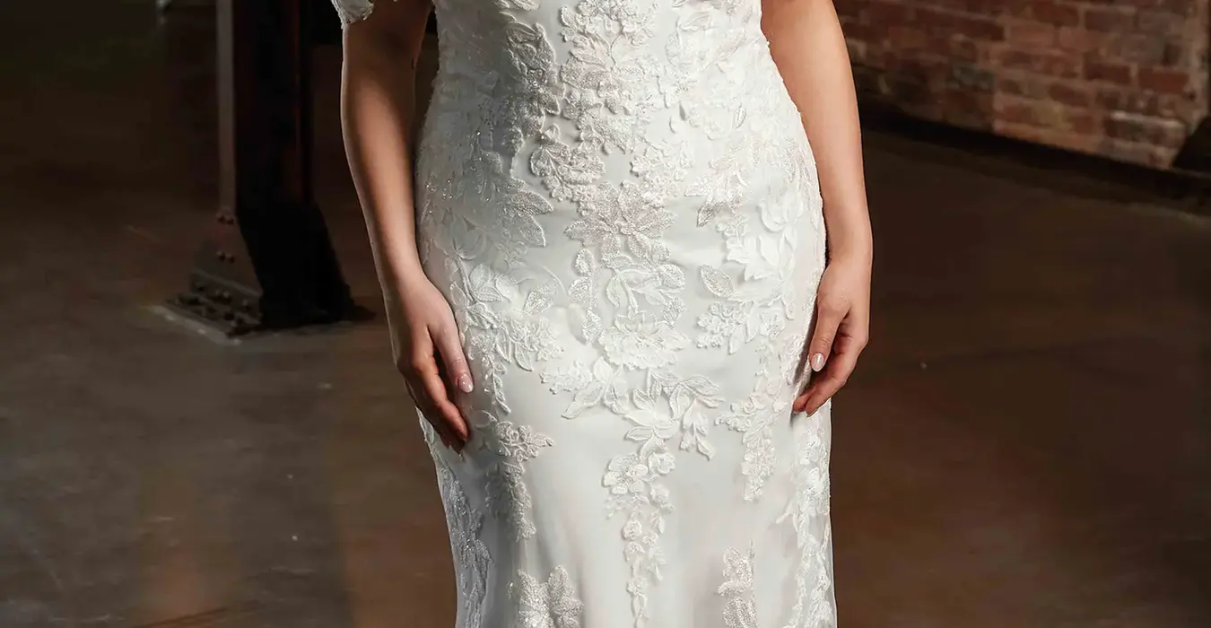 Eddy K fit-n-flare wedding dress with beaded ivory lace and sequins over tulle on bride in warehouse setting with pretty lights in background