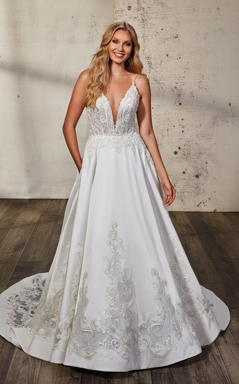 a front view of a blonde model with hair down to the side wearing a spaghetti strap ball gown