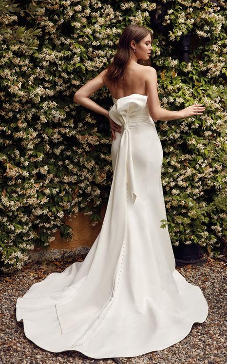 Ivory satin wedding gown with ruched bodice and detachable back bow at garden wedding