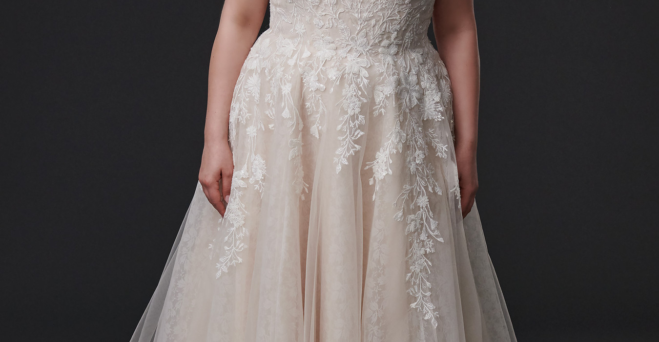 Curvy bride wearing champagne tulle a-line wedding gown with ivory lace and off-shoulder sleeves with all over lace underlay