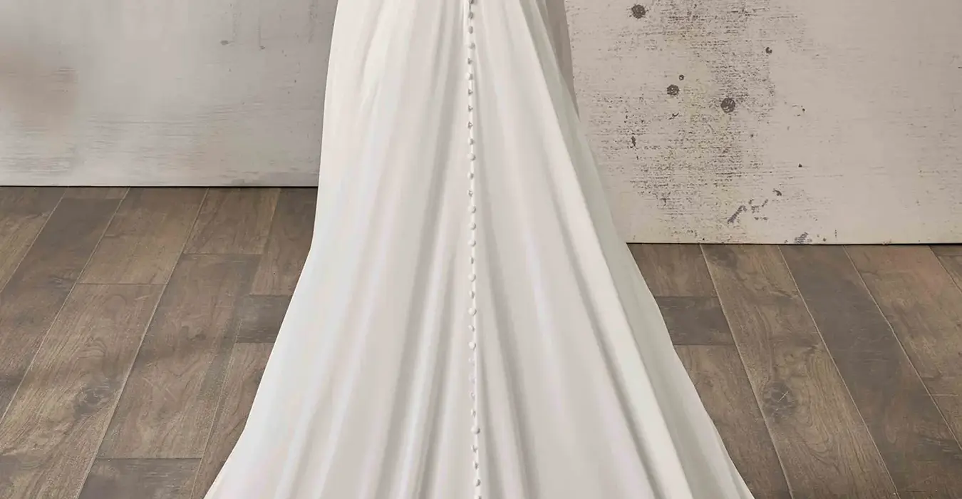 Back of Eddy K chiffon a-line wedding dress with a v-neck neckline and a sleeveless body on a bridal model posing in a studio.