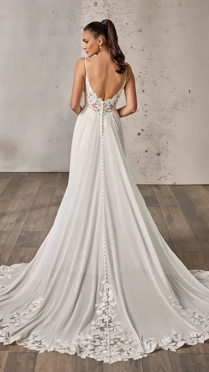 Back of Eddy K chiffon a-line wedding dress with a v-neck neckline and a sleeveless body on a bridal model posing in a studio.