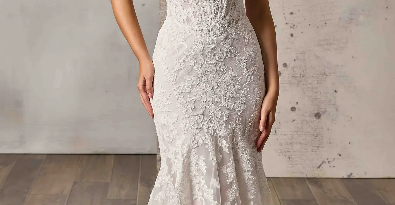 Eddy K lace fit-n-flare wedding dress with a sweetheart neckline and a sleeveless body on a bridal model posing in a studio.