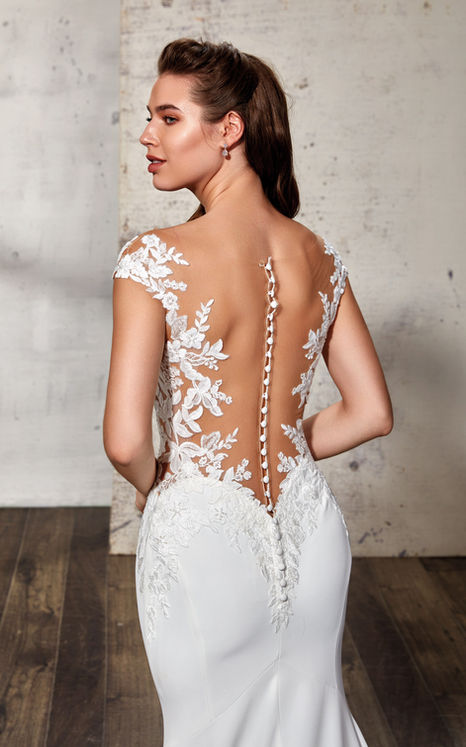 Back close up of woman wearing Eddy K mermaid wedding gown with beaded ivory lace and sequins unlined bodice over Crepe with an illusion train 