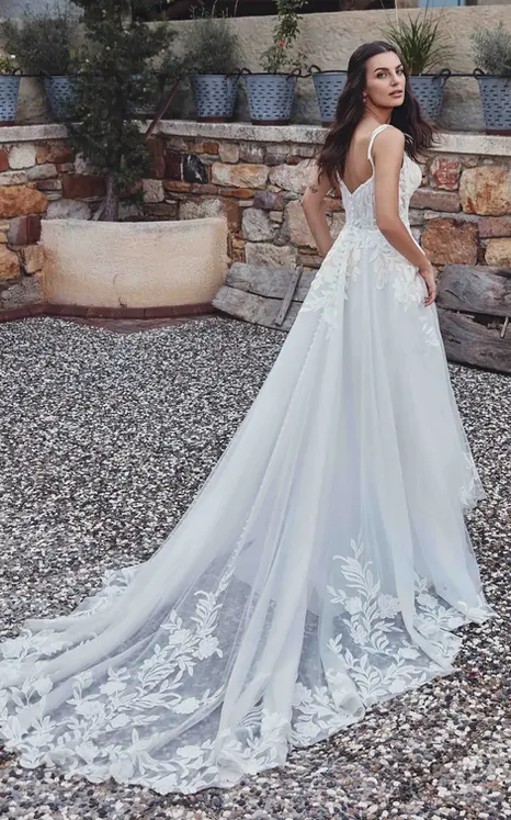 Back of Eddy K A-Line wedding gown with ivory lace over ivory tulle, Chantilly lace unlined bodice on bridal model standing in garden.