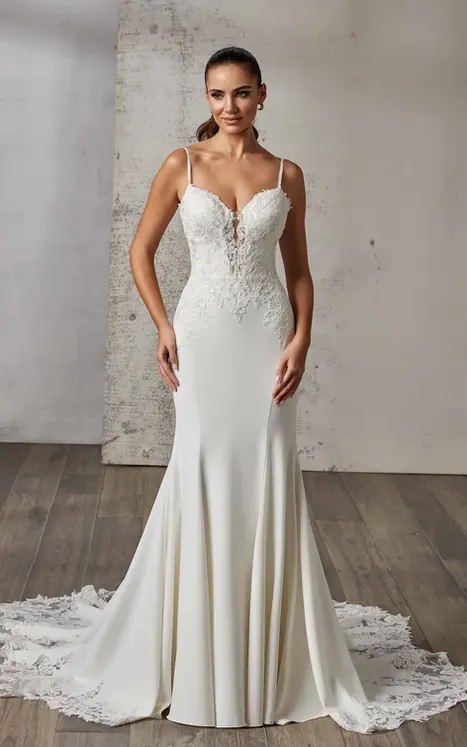 Eddy K fit-n-flare in crepe with lace on bodice, skin cleavage and beaded spaghetti straps on bridal model standing in studio.