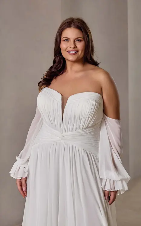 Close up of Eddy K chiffon a-line wedding dress with a sweetheart neckline and a strapless bodice on a bridal model standing in an elegant studio.