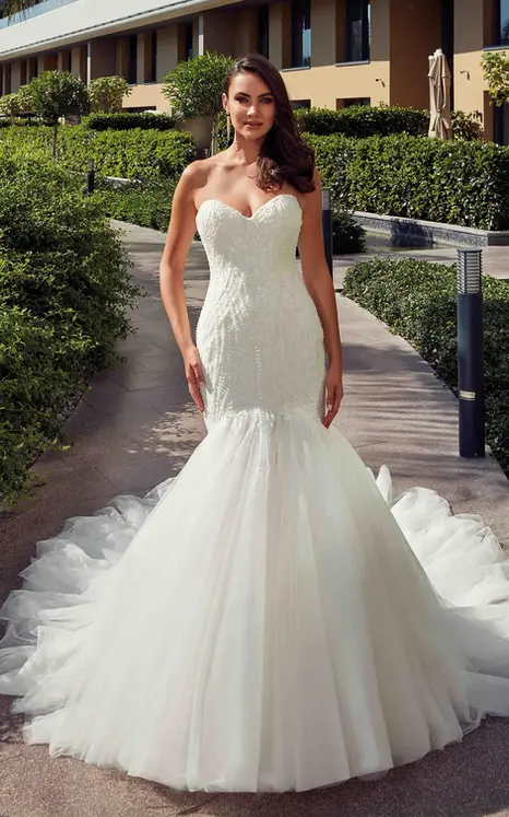 bride wearing mermaid gown by wedding dress designer, Eddy K with pearl beaded ivory embroidery over Mikado, tulle skirt, ivory matte lining, pearl buttons over zipper to skirt break. She is photographed in the city