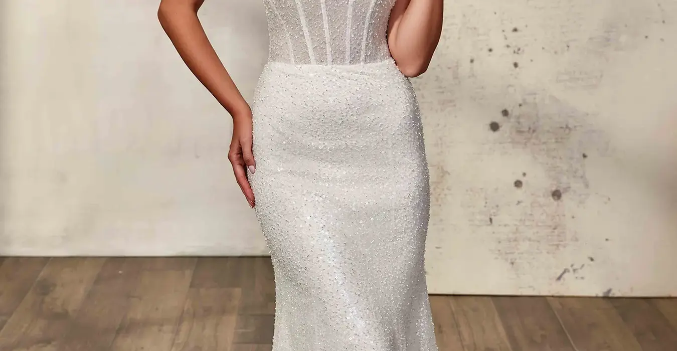 bride wearing Fit-n-Flare gown with beaded embroidered ivory tulle and sequins, sand stretchy lining, unlined bodice, buttons to end of train. She is photographed at a studio