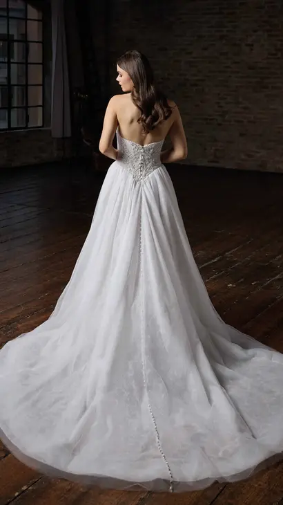Back of Eddy K ballgown wedding dress with a straight neckline and a strapless body on a bridal model posing in a studio.