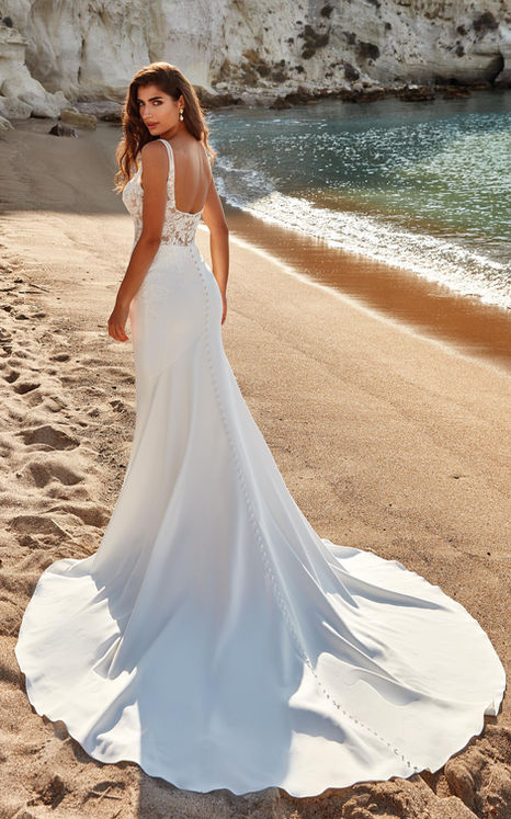 Back of model on the beach wearing Eddy K mermaid wedding gown.