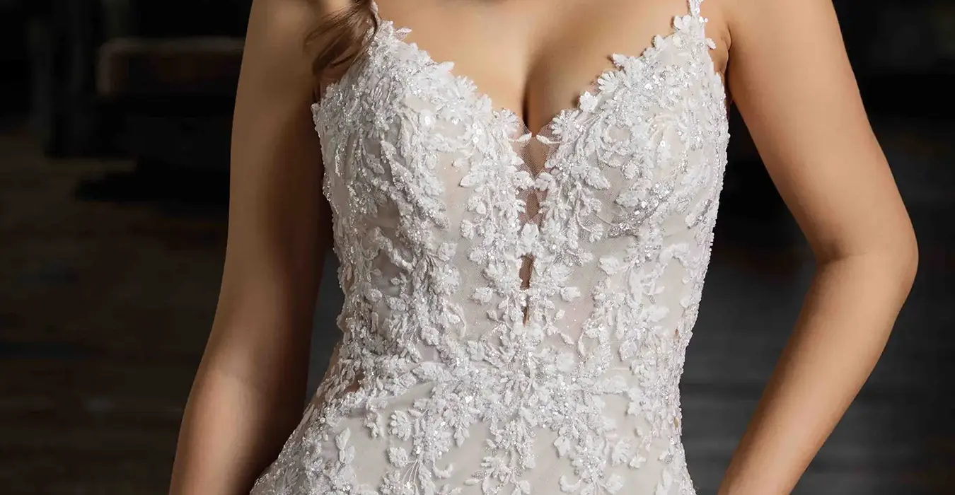 Close-up of Eddy K fit-n-flare wedding dress with a v-neck neckline and a sleeveless body on a bridal model posing in a studio.