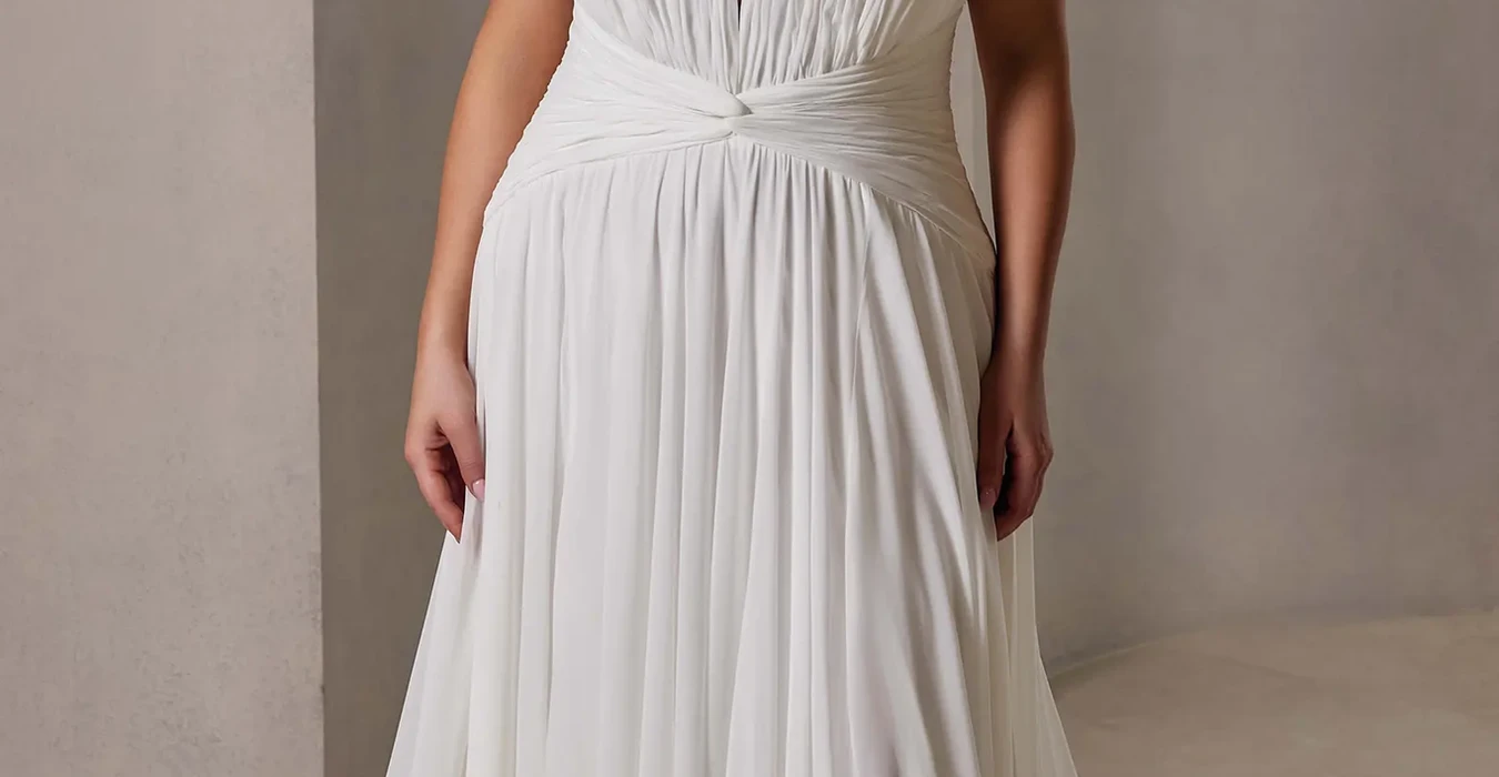 Eddy K chiffon a-line wedding dress with a sweetheart neckline and a strapless bodice on a bridal model standing in an elegant studio.
