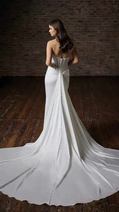 Back of Eddy K fit-n-flare dress with a sweetheart neckline and a strapless body on a bridal model posing in a studio.