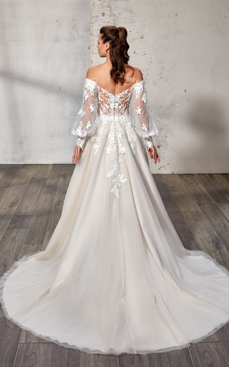 back of woman wearing Eddy K wedding ballgown with beaded ivory lace and sequins tulle and off shoulder swag sleeves.
