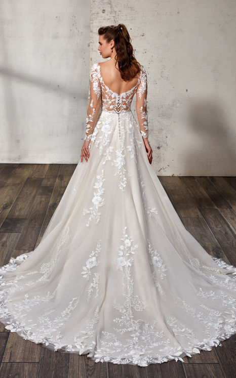 woman wearing Eddy K bridal A-Line long sleeve wedding gown with ivory lace and sequins over tulle with open back