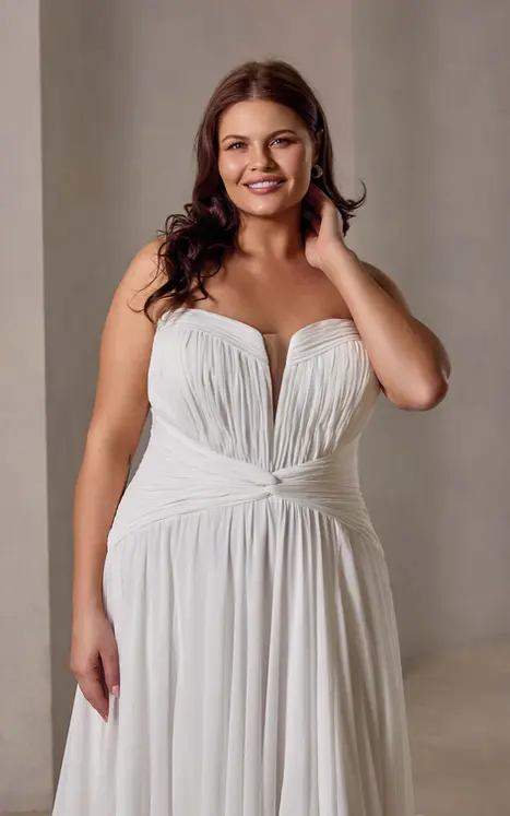Close up of Eddy K chiffon a-line wedding dress with a sweetheart neckline and a strapless bodice on a bridal model standing in an elegant studio.