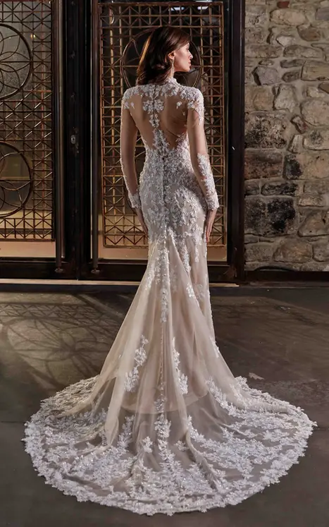 Back of Eddy K fit-n flare long sleeve with ivory lace over mocha tulle and lined skirt on bridal model standing in front of window