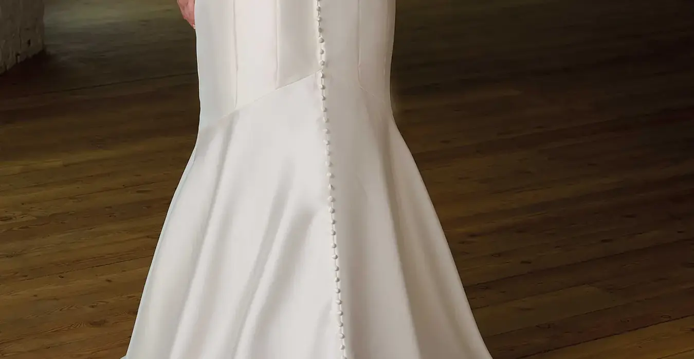 Back Mermaid Eddy K wedding dress with a straight neckline and a strapless body on a bridal model posing in a studio.